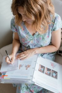 Sarah reviewing the TASK (The Academy of Systematic Kinesiology) course manual to support a client with personalized, holistic care.